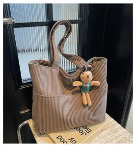 Detail of dark brown corduroy tote bag with front pocket and cute rabbit pendant