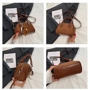 Detail of retro brown patchwork pillow bag with wooden bead charm and suede texture