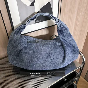 Retro acid wash denim hobo shoulder bag with zipper placed on a metal cart