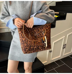 Detail of leopard print tote bag with wooden beads and branded leather patch