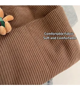 Detail of brown corduroy fabric texture with a cute plush bear charm accessory