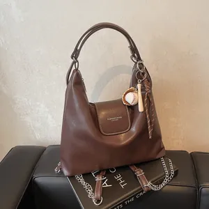 Vintage brown oil-wax leather tote backpack with baseball charm and tassel detail