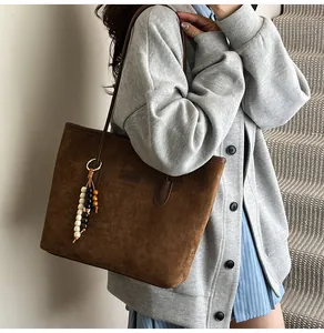 Detail of dark brown faux suede tote bag with decorative colorful wooden beads