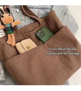 Brown corduroy tote bag detail showing front patch pocket with phone and cute rabbit charm