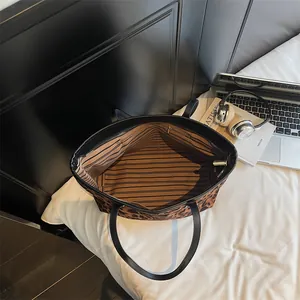 Grand sac cabas léopard avec anses en cuir et vue sur la doublure intérieure rayée