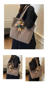 Detail view of brown corduroy tote bag with side pocket and cute rabbit charm