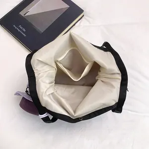 Minimalist black canvas tote bag with large capacity interior and purple fabric detail