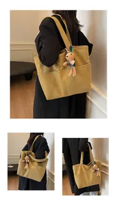 Detail view of ginger corduroy tote bag with plush rabbit charm and wide shoulder straps