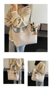 Macro detail of apricot corduroy tote bag showing vertical texture and rabbit plush charm