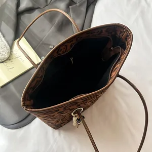 Large capacity leopard print tote bag with brown handles and plush charm detail