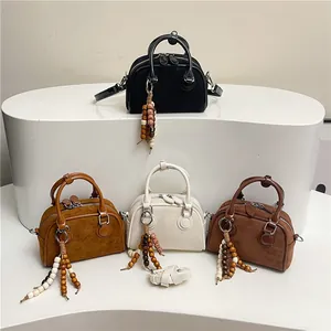 Minimalist Boston pillow handbags in four matte colors with ethnic wood bead tassels
