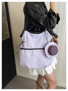 Macro detail of purple nylon tote bag featuring drawstring closure and mini hat charm