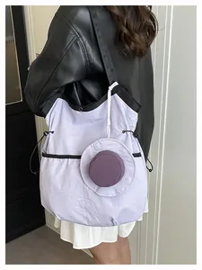 Detail of light purple canvas tote with black strap and small round zipper pouch attachment