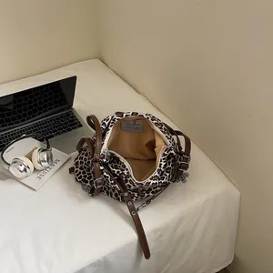 Chic leopard print tote bag with brown straps and silver chain in a lifestyle office setting