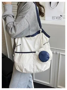 Detail of large canvas tote bag in navy blue and white with creative mini hat charm