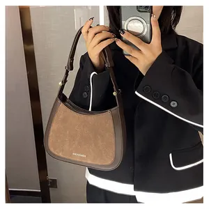 Détail du sac sous le bras demi-lune marron avec texture suédée et coutures contrastées