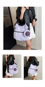 Detail of light purple canvas tote with wide black strap and mini hat charm ornament