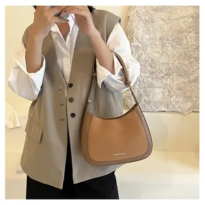 Détail du sac sous l'aisselle bicolore avec texture mate et bandoulière réglable