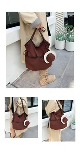 Close-up of chocolate brown nylon tote bag with drawstring detail and mini hat charm
