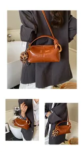 Detailed view of brown retro pillow bag with leopard print charm and wide shoulder strap