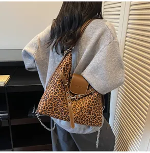 Detail of leopard print tote bag featuring a chain strap and brown faux leather flap