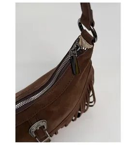 Détail de sac en daim vintage avec franges et fermeture éclair métallique lisse