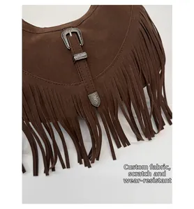 Détail d'un sac bohème en daim marron avec boucle ciselée et longues franges