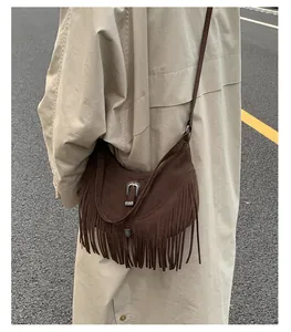 Détail du sac bohème en daim marron avec de longues franges et une boucle argentée