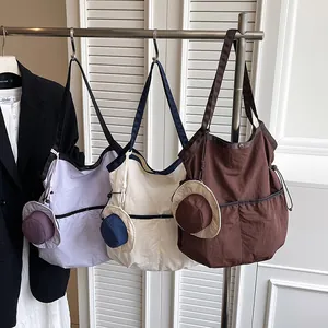 Minimalist canvas tote bags in purple, white, and brown with mini hat charms on hangers