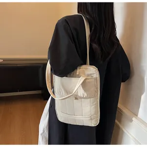 Dettaglio della borsa porta PC trapuntata beige con manico e tracolla sottile