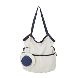 Minimalist canvas tote bag with navy trim and side drawstrings for daily commute usage