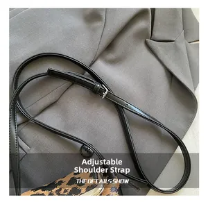 Detail eines verstellbaren Leder-Schultergurts mit Silberschnalle an der Leoparden-Mini-Tasche