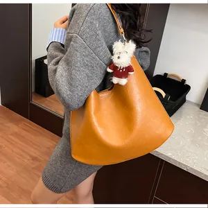 Caramel large tote bag with puppy charm shown on model in modern casual style