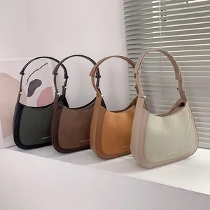 Sacs portés épaule minimalistes en quatre couleurs sur marches blanches sous lumière douce