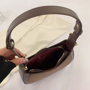 Sac à bandoulière minimaliste marron contrasté avec fermeture éclair et doublure rouge