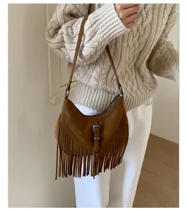 Gros plan sur un sac en daim marron avec de longues franges et une boucle rétro en métal