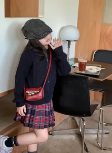 Detail einer roten Lackleder-Umhängetasche kombiniert mit einem Vintage-Outfit für Mädchen