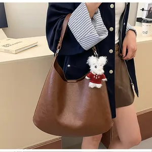 Brown textured PU leather hobo bag featuring a cute white bear charm and metal buckle detail