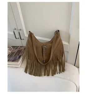 Gros plan détaillé du sac hobo en daim marron avec franges rétro et boucle argentée