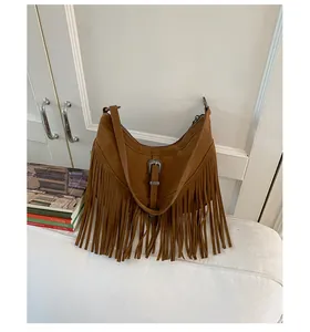Détail du sac bandoulière bohème en daim marron foncé avec boucle et longues franges