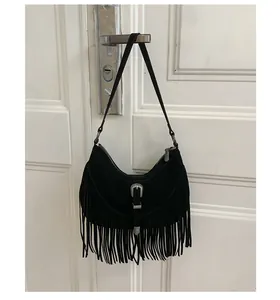 Détail du sac hobo noir bohème avec de longues franges et une boucle en métal vintage