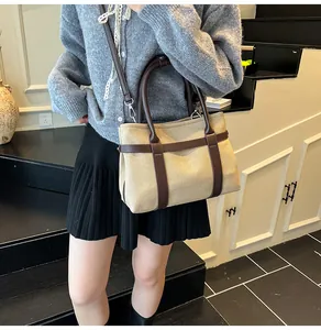 Beige canvas tote bag with brown leather trim shown on model for daily casual outfit
