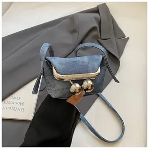 Detail der blauen Mini-Umhängetasche aus Denim mit großem silbernem Metall-Kugelverschluss