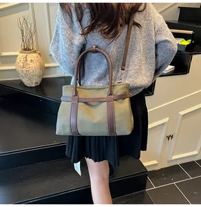 Detail of army green canvas tote with brown leather handles in a lifestyle setting