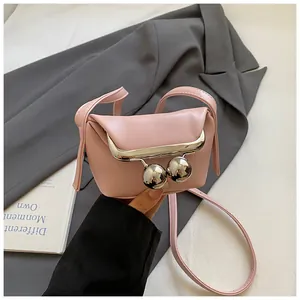 Draufsicht der rosa Mini-Clip-Tasche mit silbernen Kugelverschlüssen auf grauem Blazer