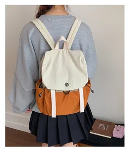 Détail du sac à dos de camping bicolore crème et orange avec badge GM et cordon