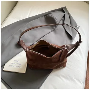 Retro brown suede leopard print hobo bag with silver zipper on grey suit jacket