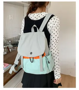 Vue détaillée de dos d'un sac à dos d'extérieur tricolore porté en intérieur