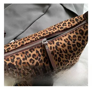 Detailed close-up of leopard print suede texture with silver zipper and leather puller