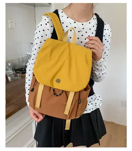 Détail du sac à dos d'extérieur bicolore avec rabat jaune et matériau en nylon brun